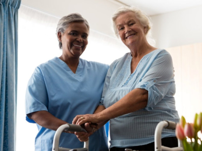physician attending to elderly woman while both of them are smiling